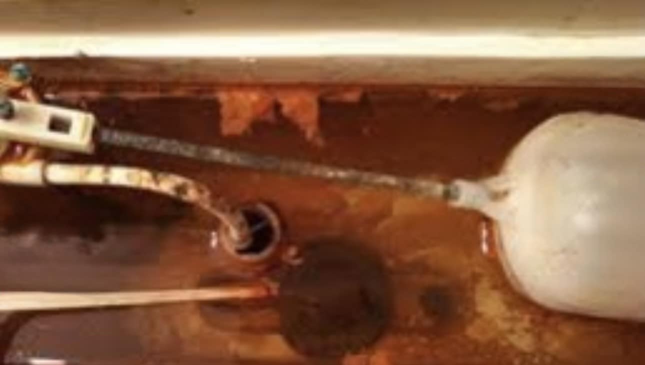 Toilet bowl with heavy orange rust stains from iron in well water
